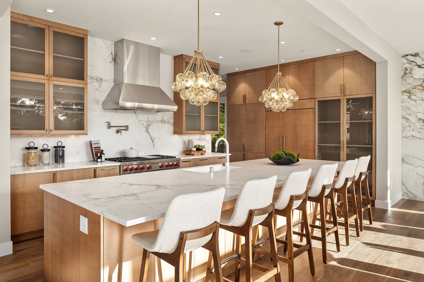 Sleek modern popular kitchen design featuring a marble island, pendant lights, and stylish wood cabinetry.