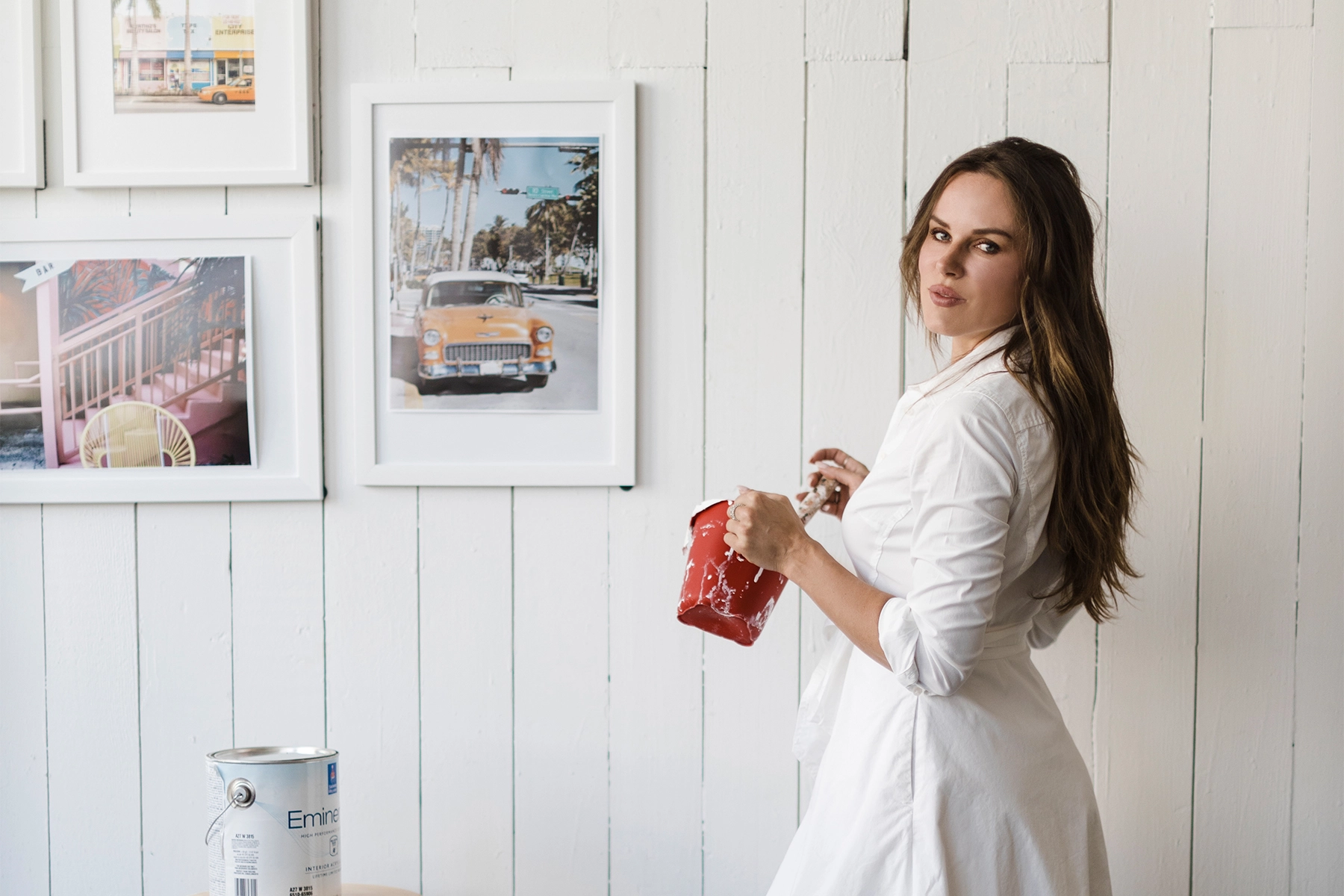 Woman painting in a bright, inviting creative space with vintage decor and warm natural light using interior design trends.