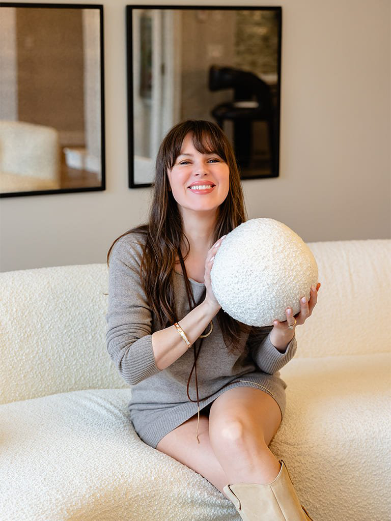 Relaxed lounge lifestyle — cozy boucle sofa with decorative sphere, Bellevue commercial space, Ariana Designs