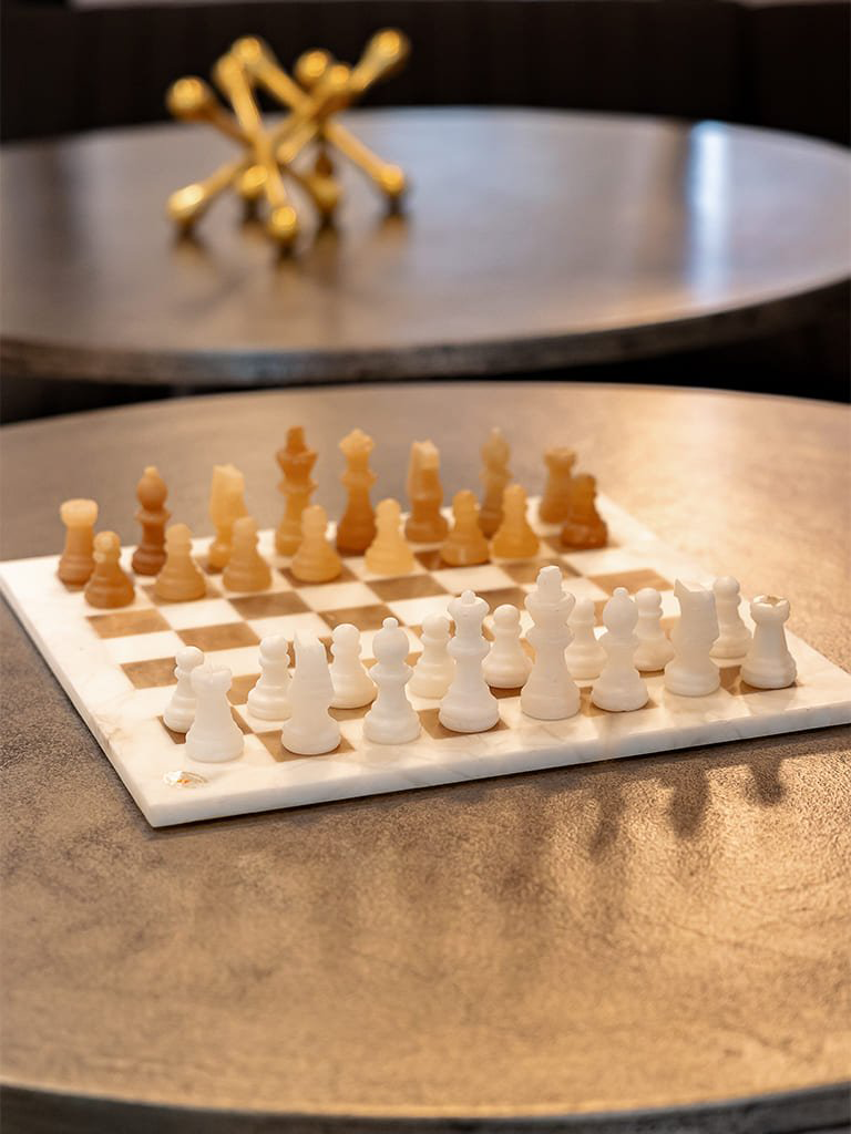 Elegant chess set on marble coffee table — Bellevue commercial lounge detail, Ariana Designs