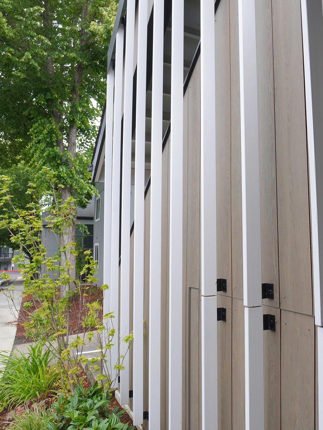 Modern architectural facade wooden panels stripes greenery — Ariana Designs