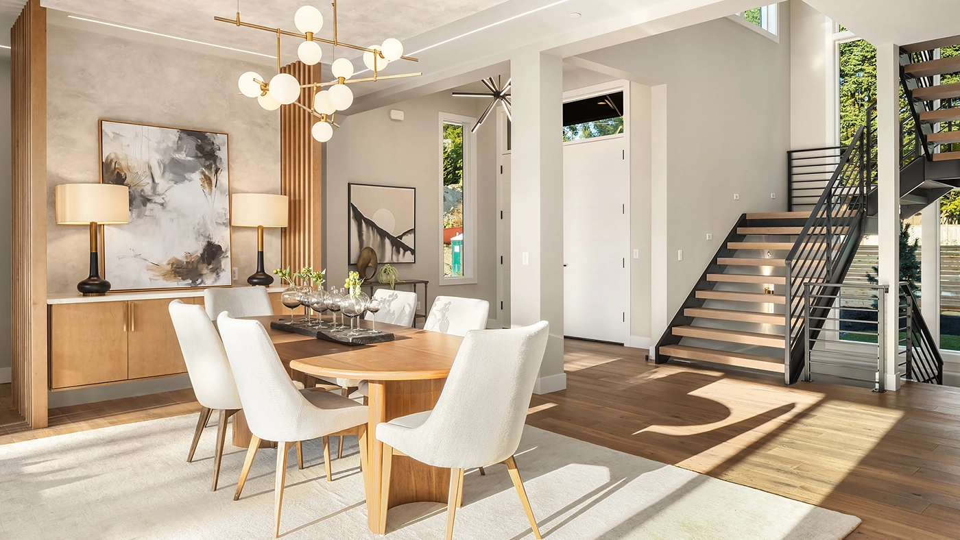 Elegant modern dining area with natural light, stylish furniture, and artistic decor.
