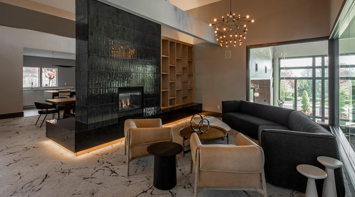 Modern living room with black glass fireplace, stylish seating, and natural light.