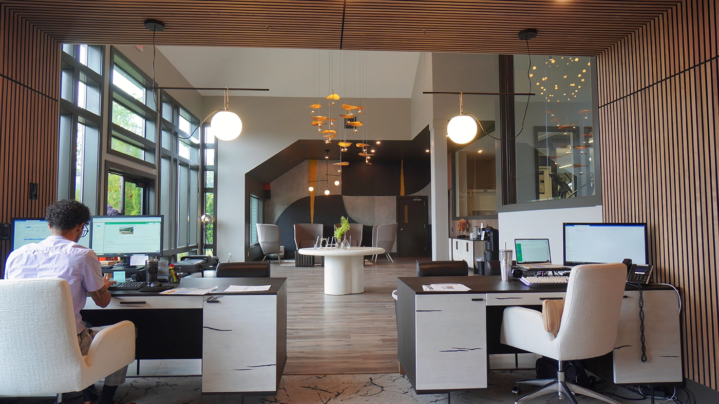 Modern office space with sleek desks, natural light, and stylish lounge area for collaboration.