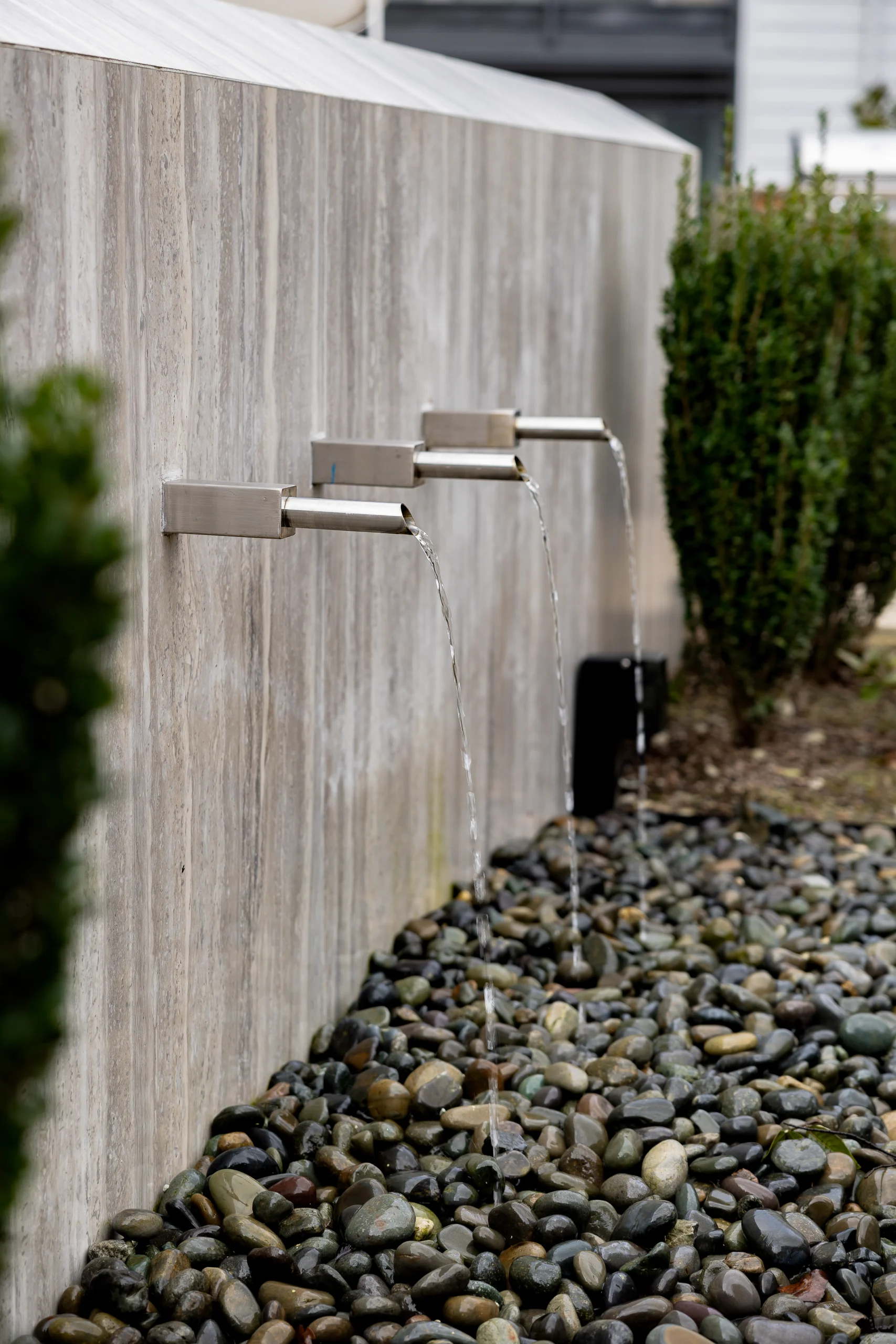 Modern water feature spouts stones shrubs outdoor — Ariana Designs, Bellevue Washington