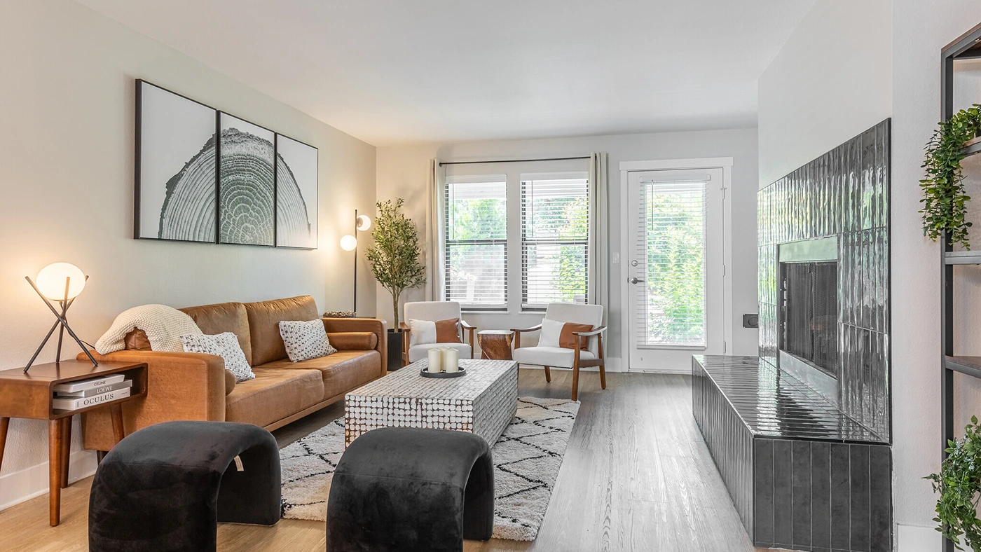 Cozy modern living room featuring a leather sofa, sophisticated decor, and abundant natural light, exemplifying luxury interior design