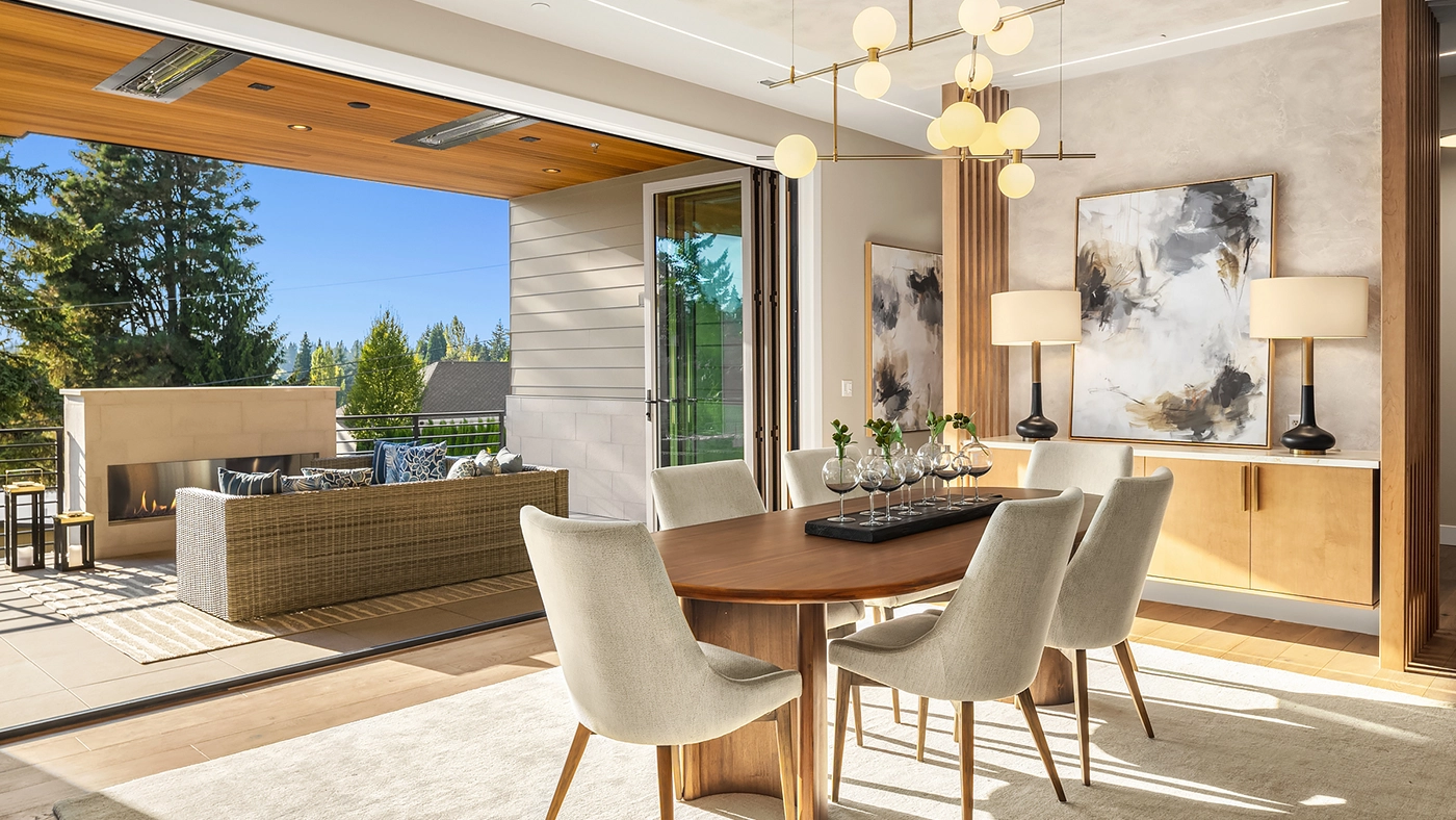 Elegant contemporary dining area with indoor-outdoor living, natural light, and stylish furnishings.
